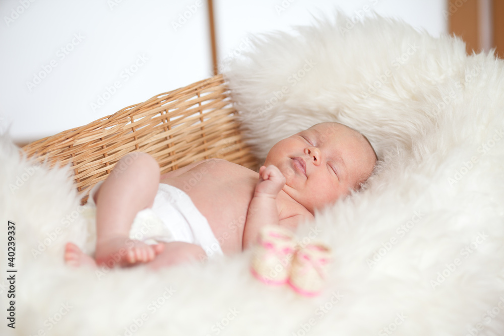 Fototapeta premium newborn adorable baby are sleeping in a wicker basket