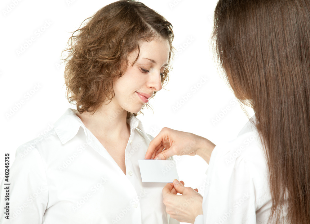 Young women fastening badge at business meeting or conference Young women fastening badge at business meeting or conference