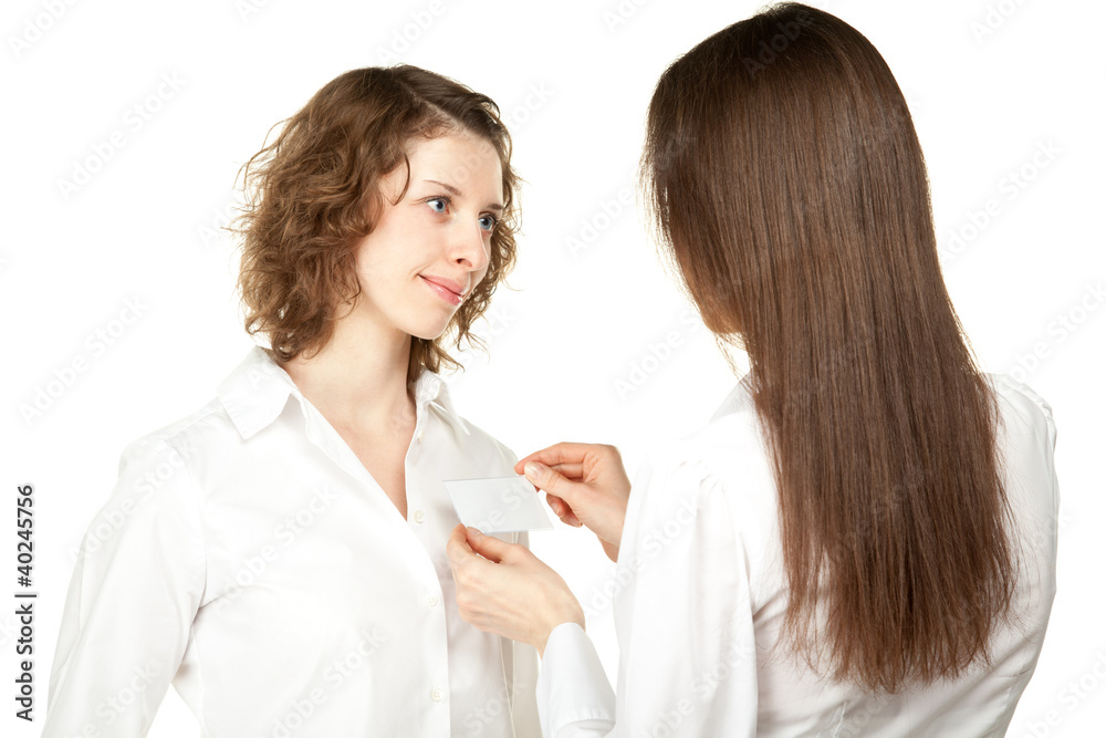 Young women fastening badge at business meeting or conference Young women fastening badge at business meeting or conference