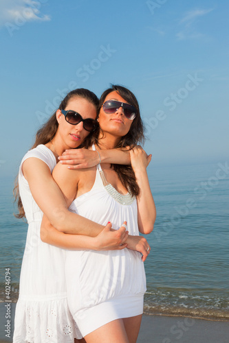 Two Female Friends Embraced on the Beach © william87