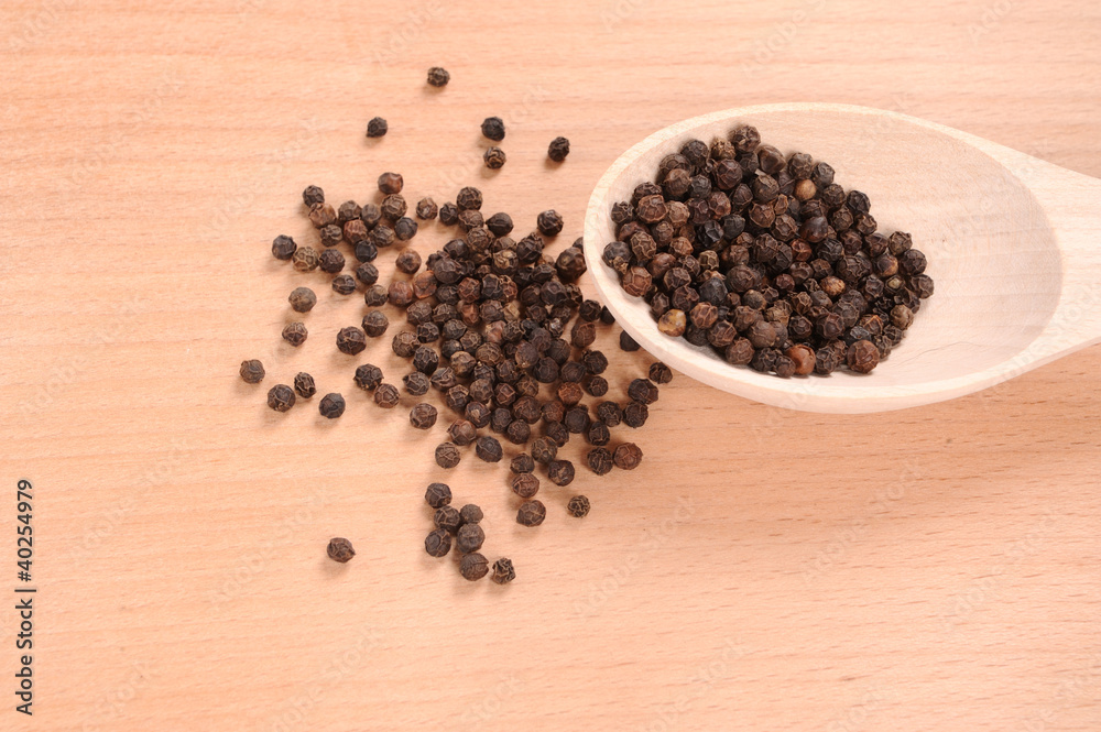 black pepper with spoon on the wooden cutting board black pepper with spoon on the wooden cutting board