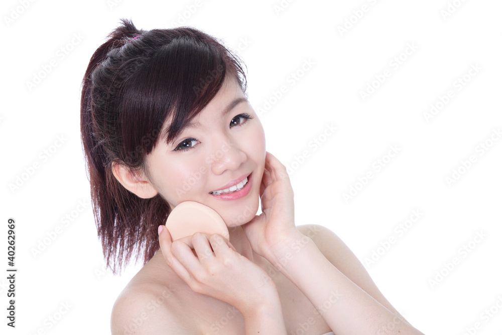 Woman using cosmetic sponge on face with smile Woman using cosmetic sponge on face with smile