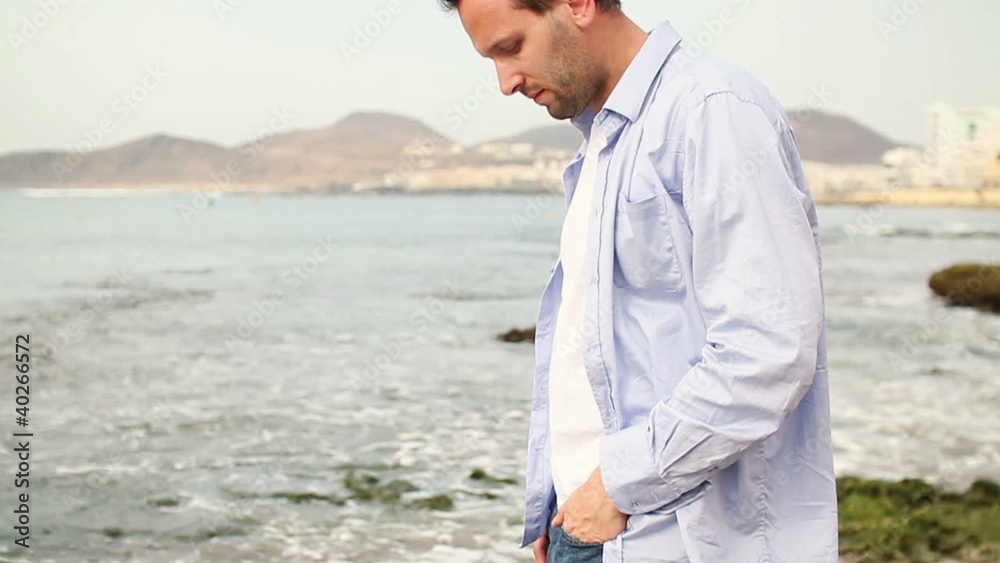 Man standing on the beach, slow motion, steadicam shot Man standing on the beach, slow motion, steadicam shot