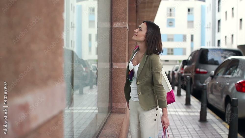 Woman with shopping bags looking at shop window in the city Woman with shopping bags looking at shop window in the city