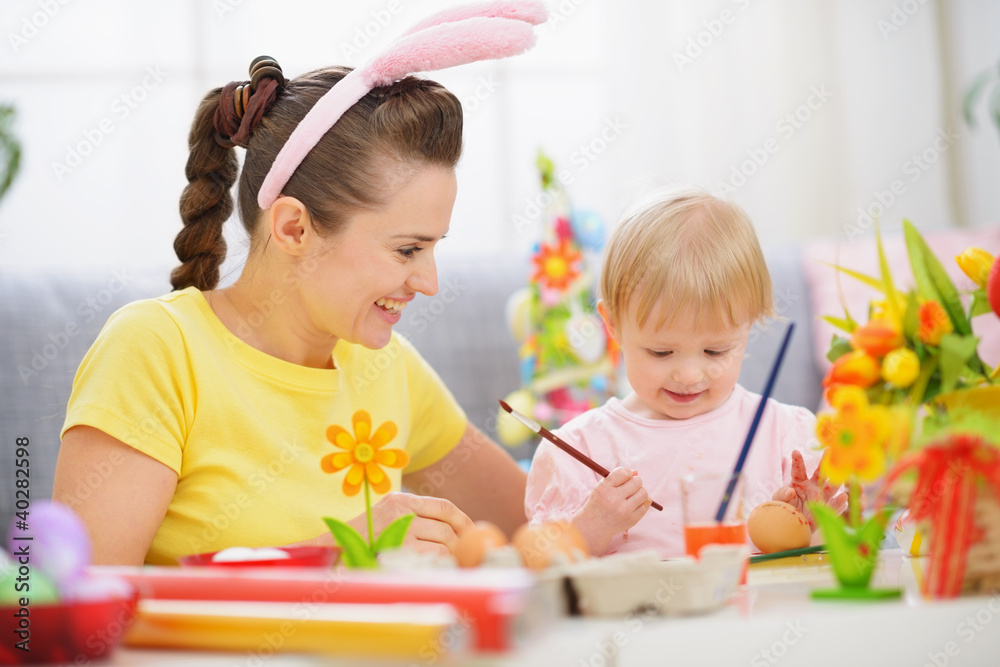 Mother and baby painting on Easter eggs Mother and baby painting on Easter eggs