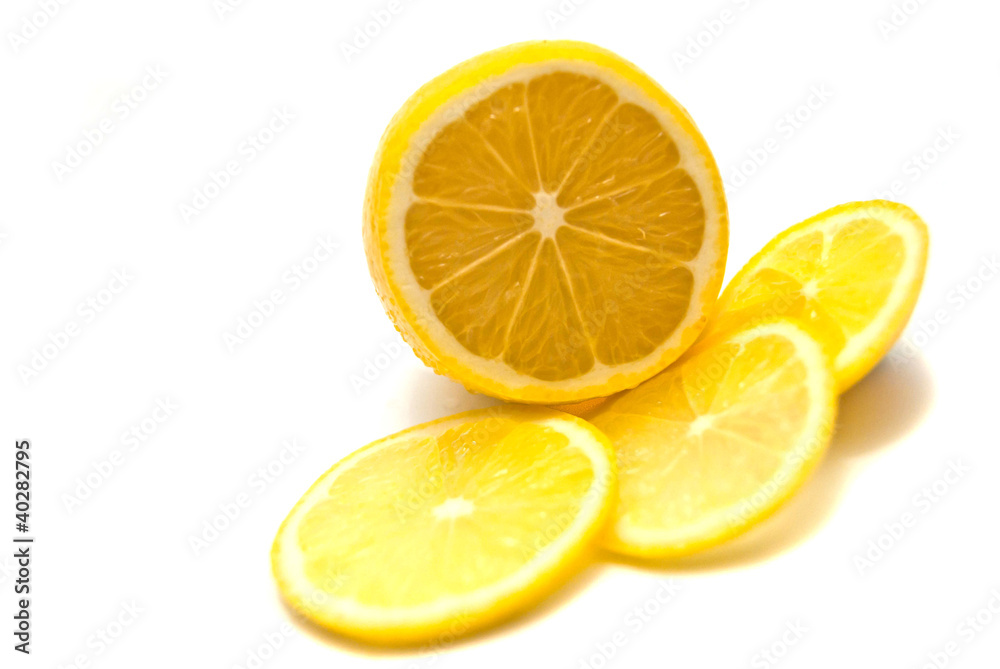 Lemon slices and fresh lemon on white