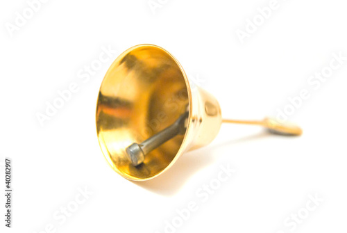 Golden handbell close-up on white