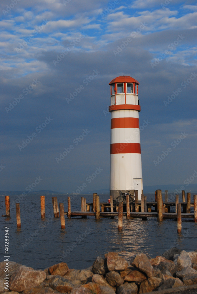 red and white striped lighthouse with a view over the lake