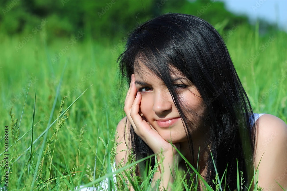 Girl with beautiful hair laying on the grass Girl with beautiful hair laying on the grass