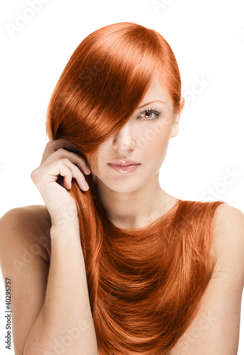 beautiful young woman holding her elegant long red shiny hair