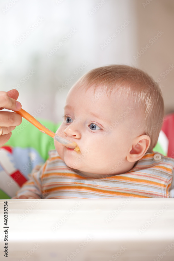 Mother feeding baby food to baby Mother feeding baby food to baby