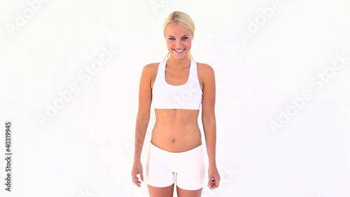 Blonde shrugging her shoulders after touching her skinny belly