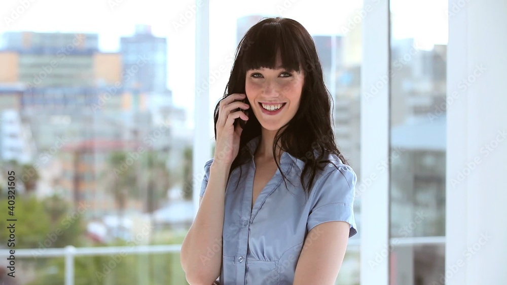 Happy brunette businesswoman using her cellphone Happy brunette businesswoman using her cellphone