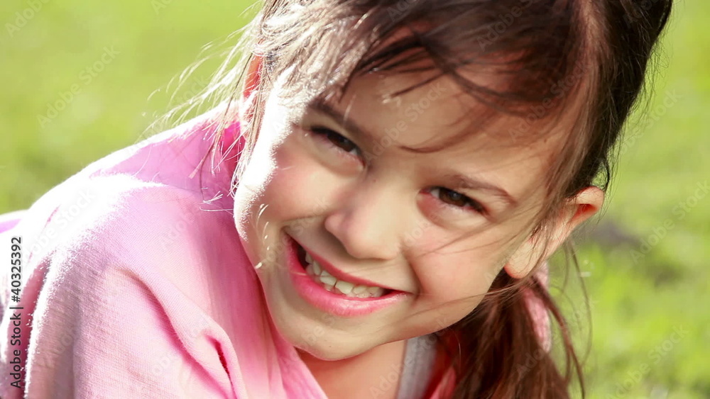 Smiling little girl lying on the grass Smiling little girl lying on the grass