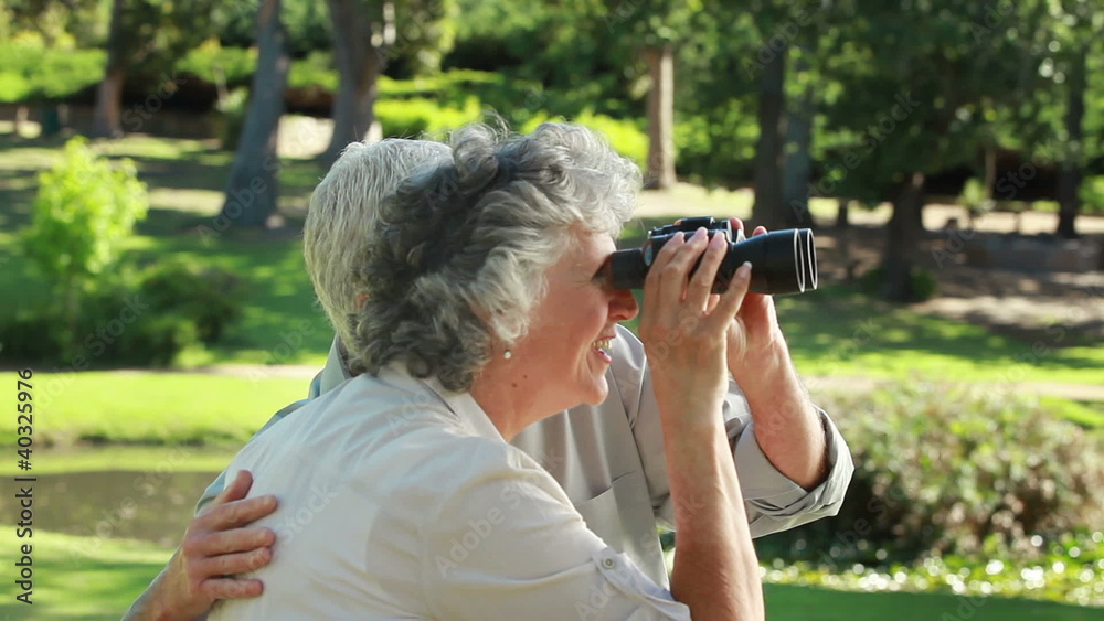 Retired couple looking through binoculars Retired couple looking through binoculars