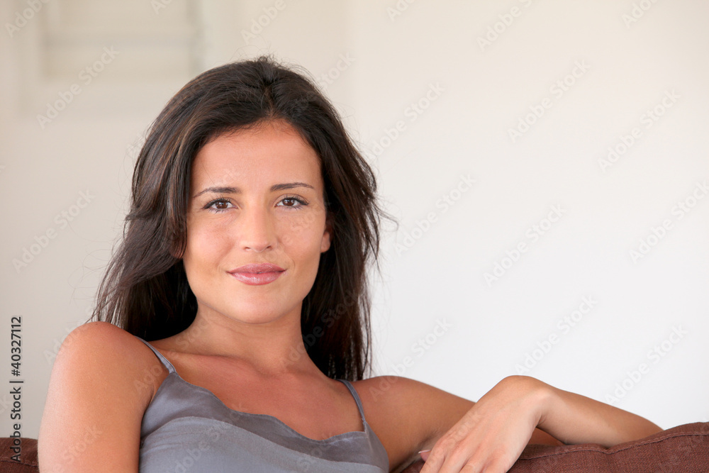 Portrait of smiling beautiful woman sitting in sofa Portrait of smiling beautiful woman sitting in sofa