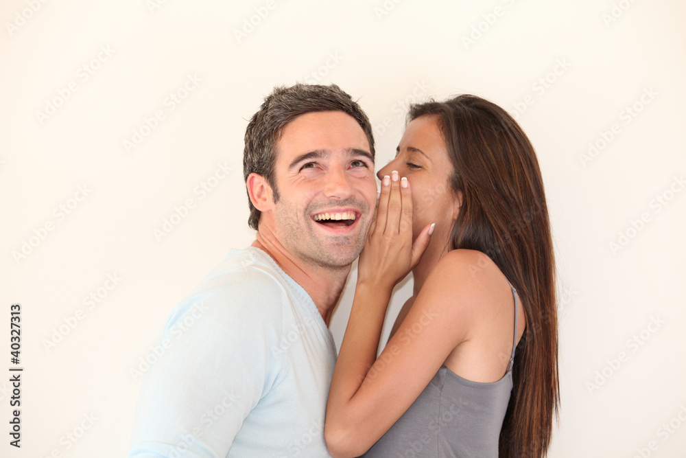 Beautiful woman whispering to boyfriend's ear Beautiful woman whispering to boyfriend's ear
