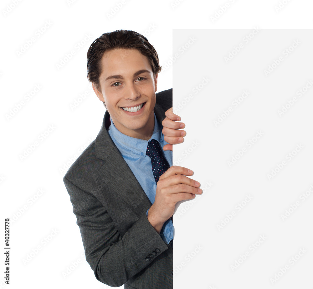 Businessman peeping from behind the blank board Businessman peeping from behind the blank board