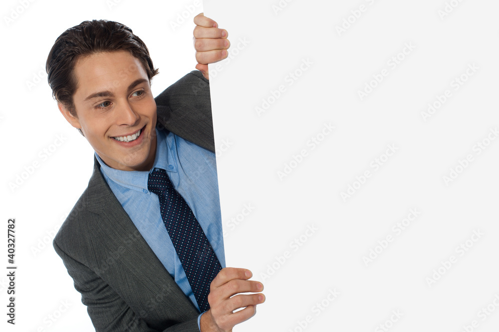 Businessman looking around the corner Businessman looking around the corner