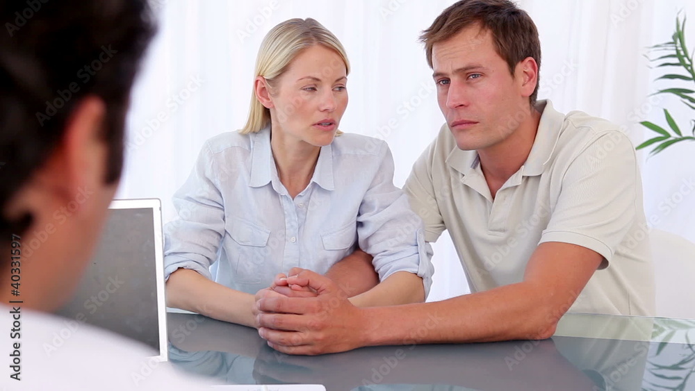Couple hugging each other while sitting in front of a doctor Couple hugging each other while sitting in front of a doctor