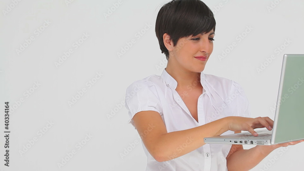 Brunette haired businesswoman typing on a laptop