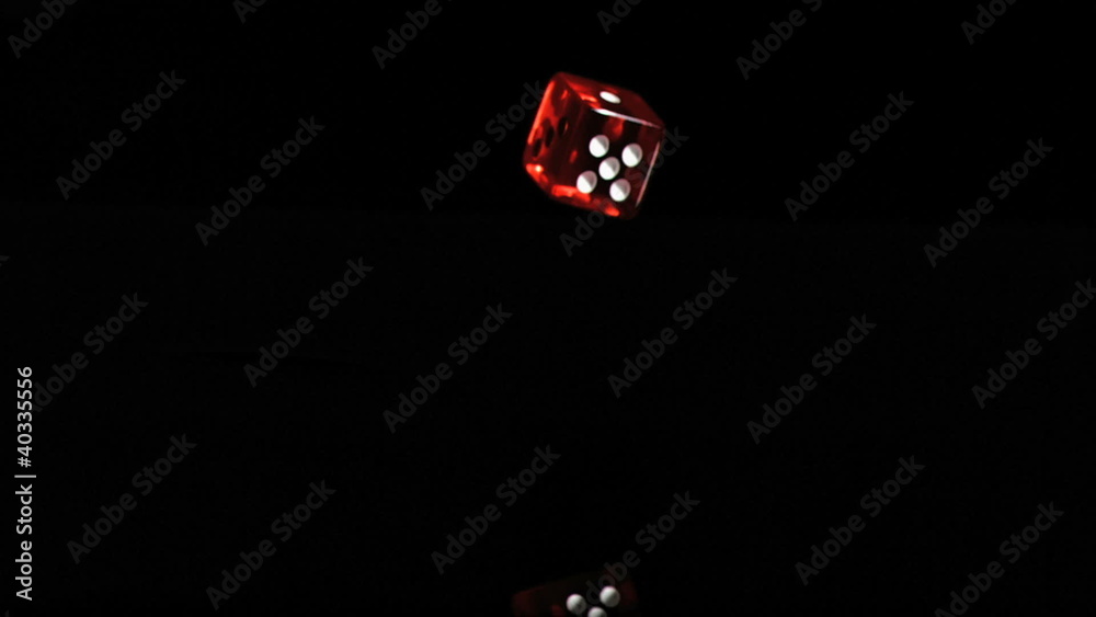 One red translucent dice in a super slow motion turning