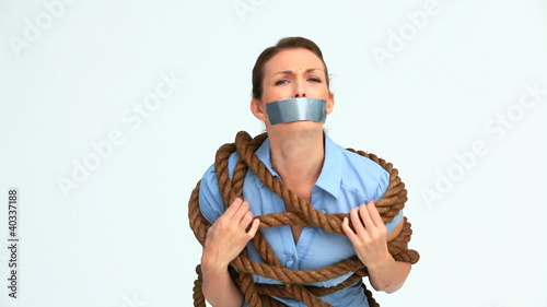 Woman with tape on the mouth and attached with a rope