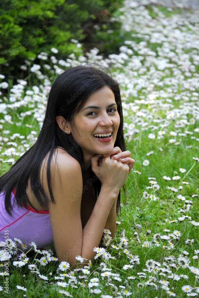 Joven mujer recostada sobre flores en primavera. Joven mujer recostada sobre flores en primavera.