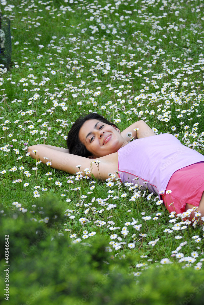 Joven mujer recostada sobre flores en primavera. Joven mujer recostada sobre flores en primavera.
