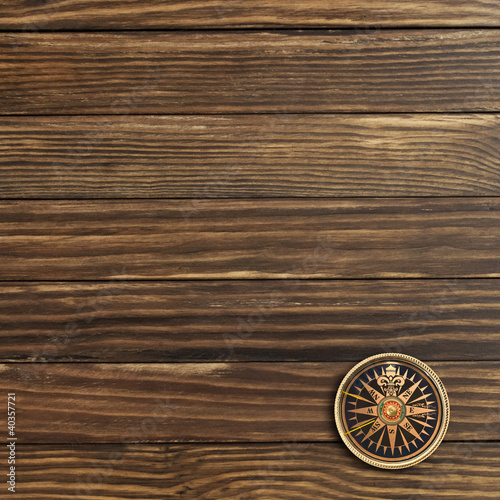 Compass on the old wooden background