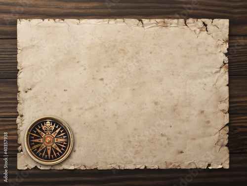 old paper and compass on a wooden background