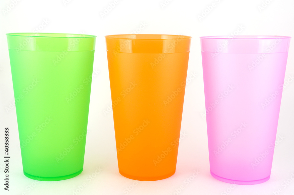Green, orange and pink cups over white Green, orange and pink cups over white
