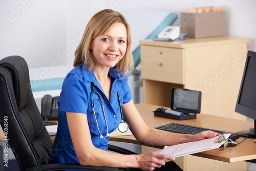 Portrait UK doctor sitting at desk photo