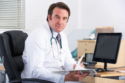 Portrait UK doctor sitting at desk