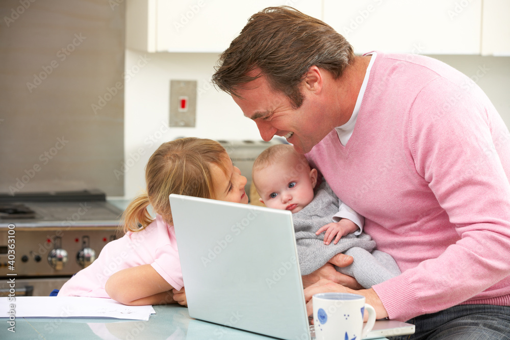 Father with children using laptop in kitchen Father with children using laptop in kitchen