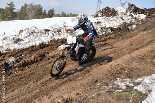 Motocross athlete is accelerating on a sandy slope