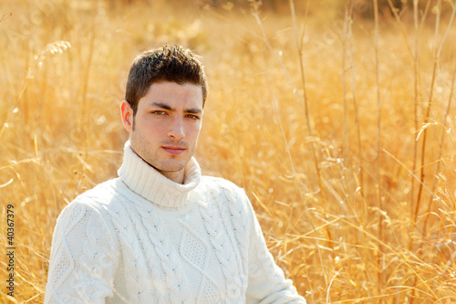 Autumn winter man portrait in outdoor dried grass