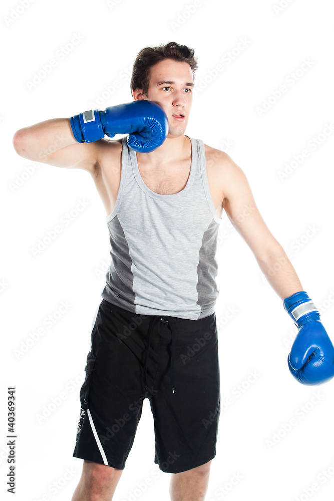 young boxer in gray shirt and blue boxing gloves young boxer in gray shirt and blue boxing gloves