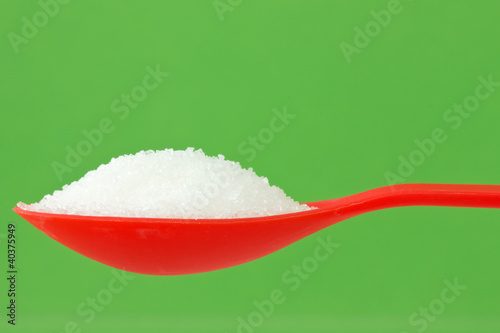 Tableau sur toile spoon with sugar on green background