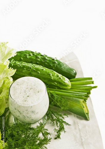 Dairy-grassy drink,  parsley, cucumber , salad leaves on white