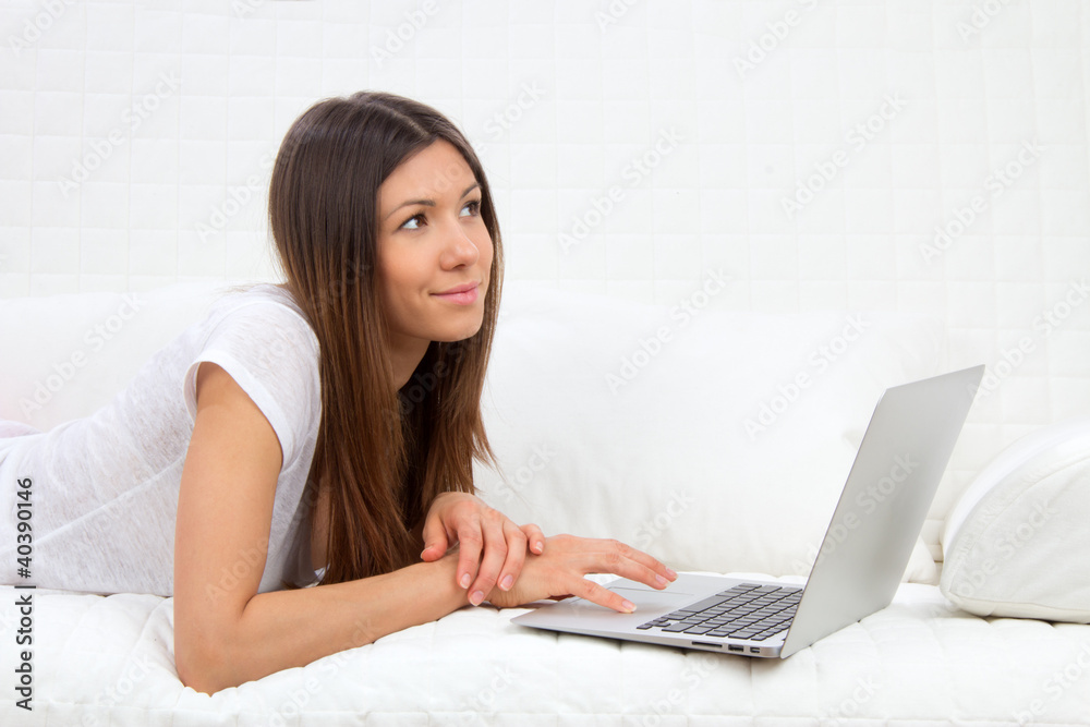 Young succesful woman lying on a sofa with laptop Young succesful woman lying on a sofa with laptop