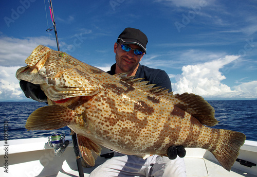 Happy  fisherman holding a grouper photo