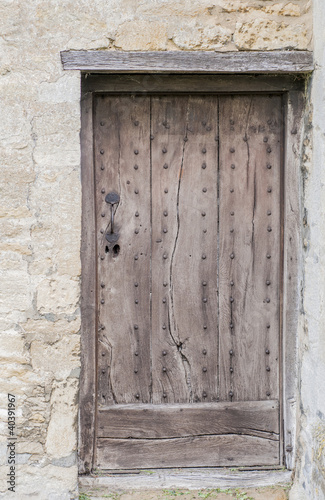 Old wooden door with a wooden lintel set in stone