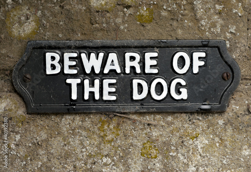 Beware of the dog sign screwed onto stone