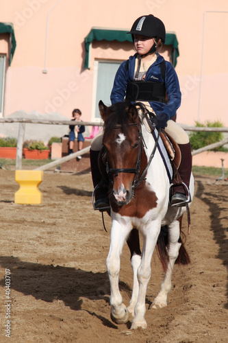 bambina a lezione di equitazione