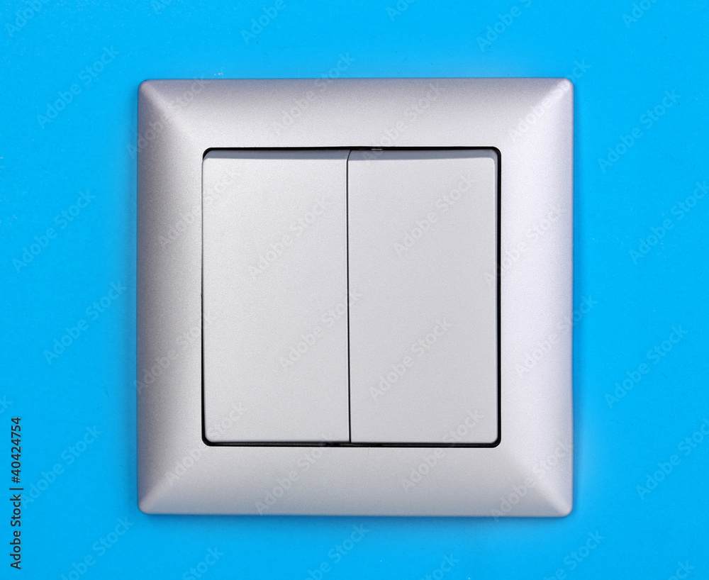 Modern light switch on blue background Modern light switch on blue background