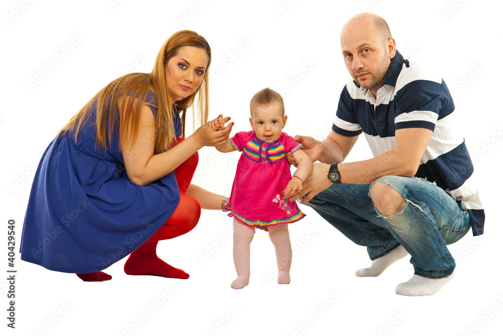 Obraz premium Young parents hold baby to make first steps