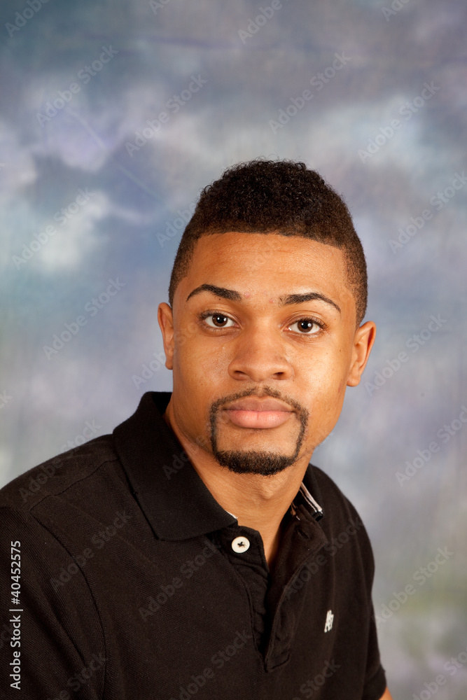 Black man looking at the camera with a  thoughtful with a smile