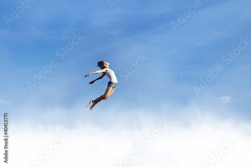 Freedom: Woman jumping over the clouds