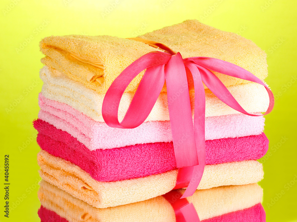 Colorful towels with ribbon on green background Colorful towels with ribbon on green background